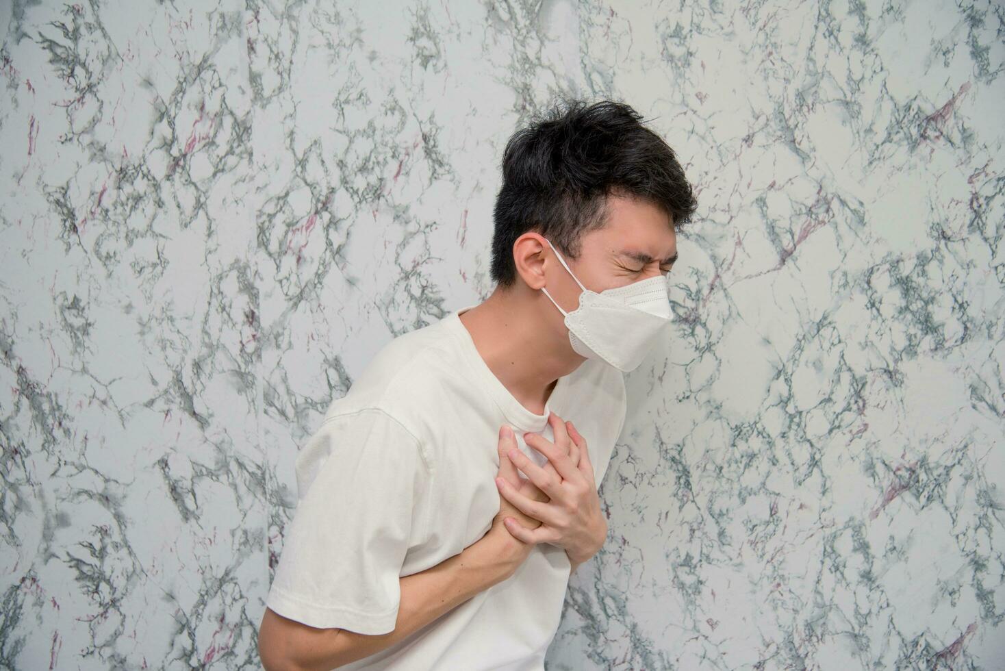 Man puts on a face mask chest pain isolated on White background,pandemic and social distancing concept.Covid-19 photo