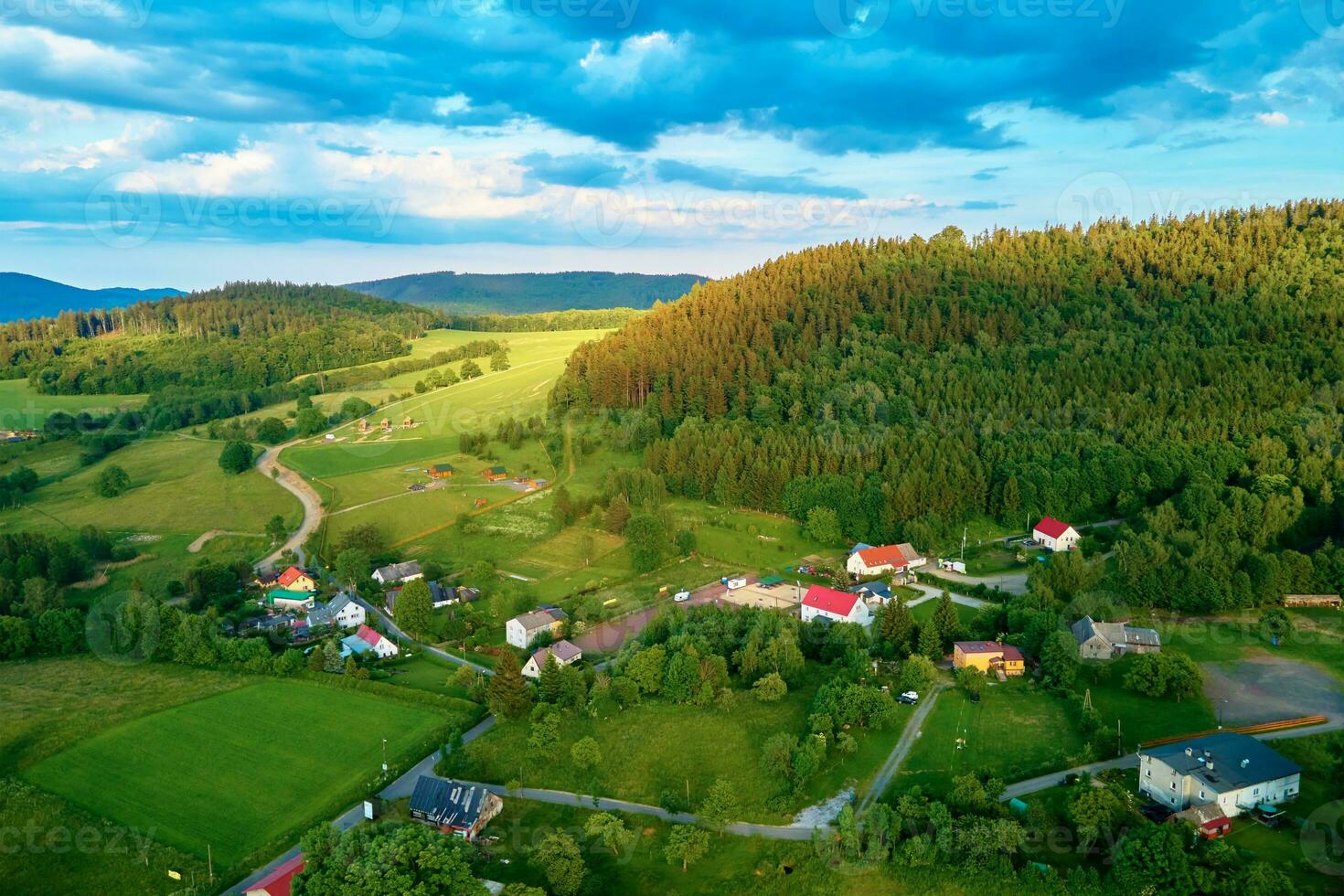 Aerial view of countryside area with village and mountains photo