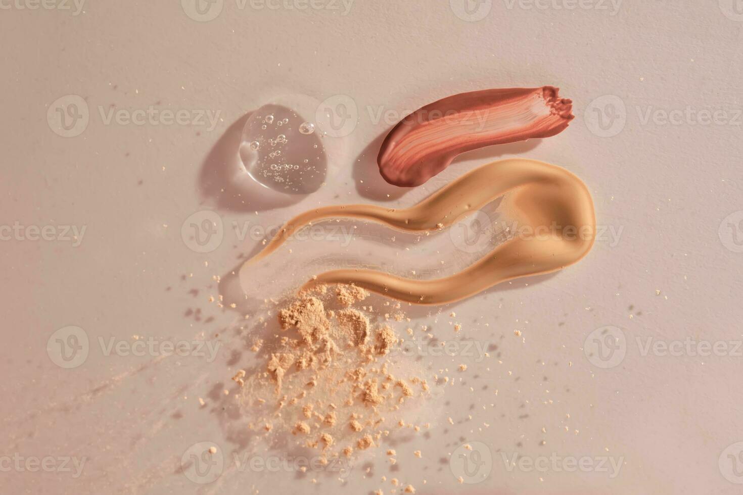 A sample of red lip gloss, foundation, powder and gel makeup base. photo