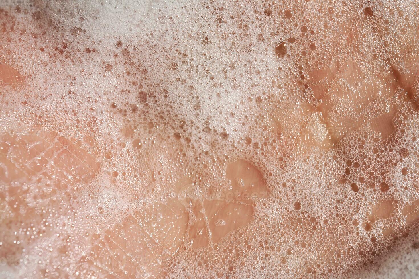 Photo of the texture of cosmetic foam or soap on the hand.
