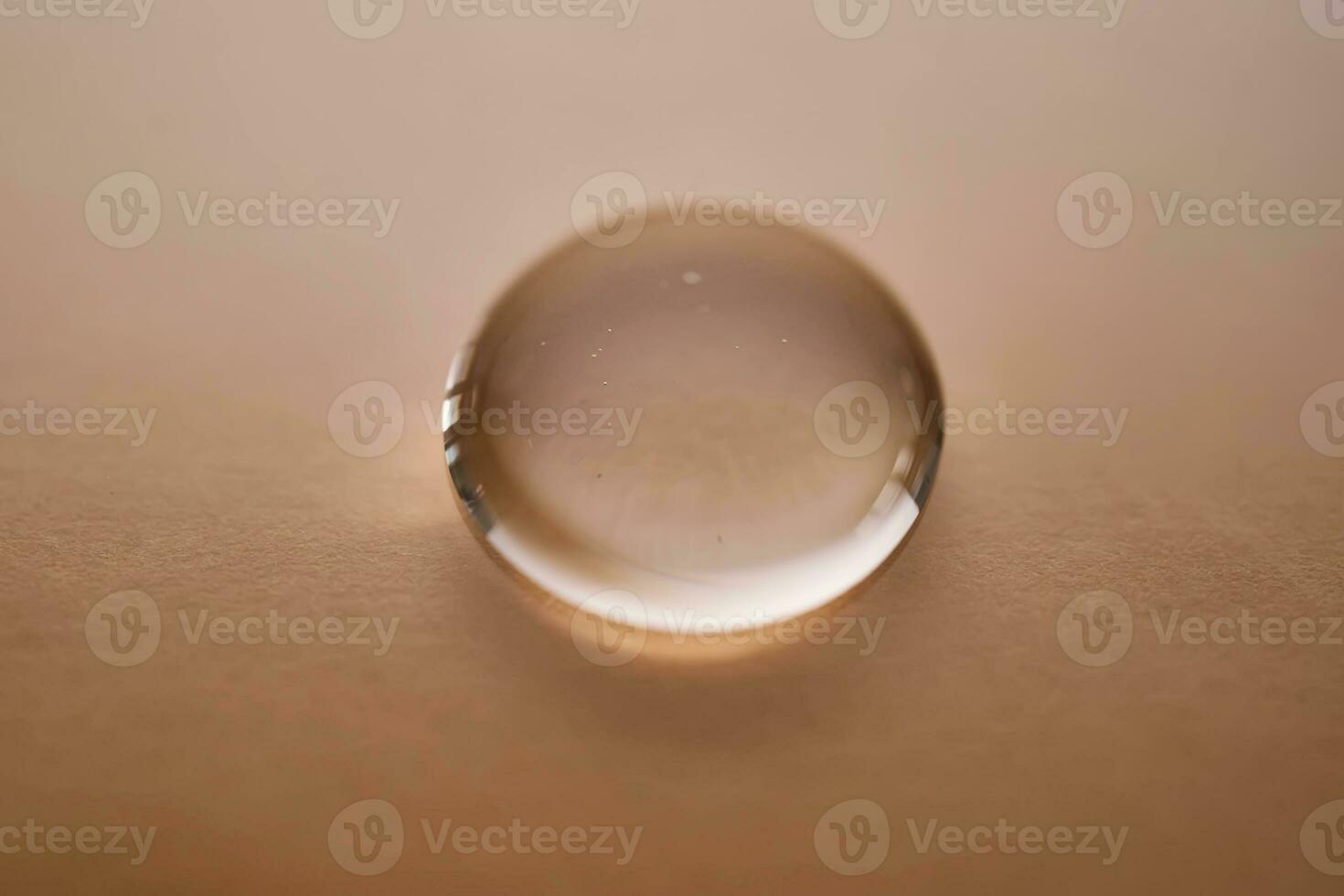 A juicy drop of gel on a beige background. photo