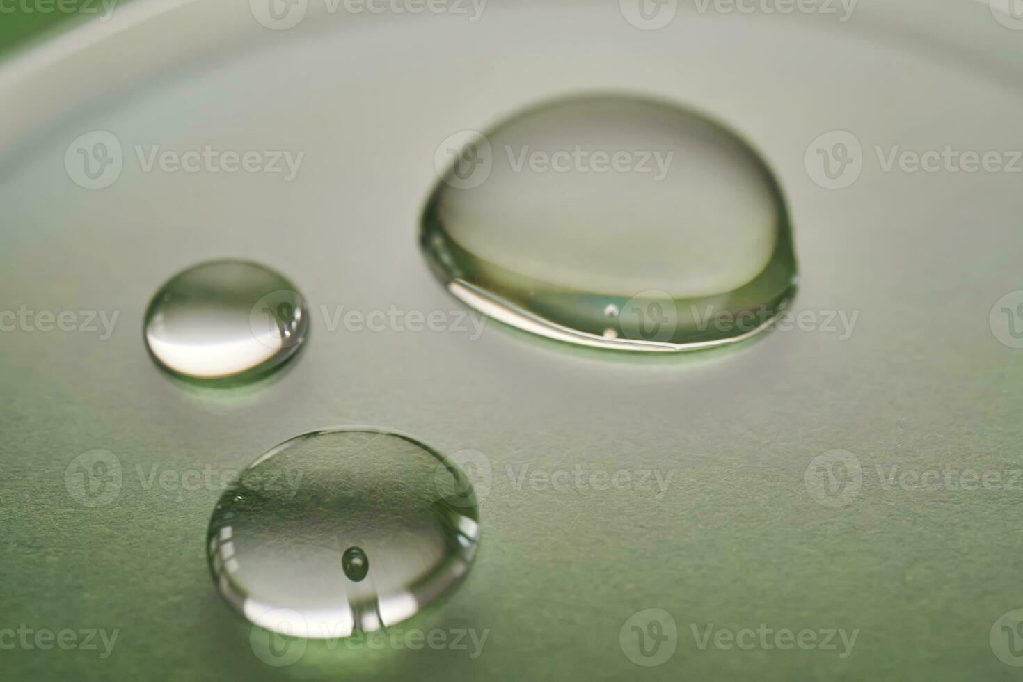 Tres gotas de líquido en un verde antecedentes. foto