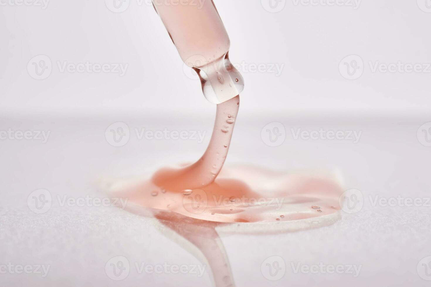 Pipette with a viscous pink cosmetic close-up. photo