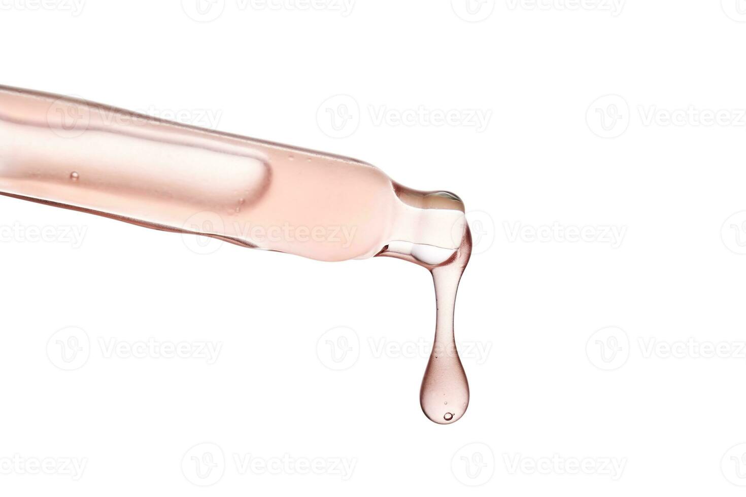 Pipette with a viscous pink cosmetic close-up. photo