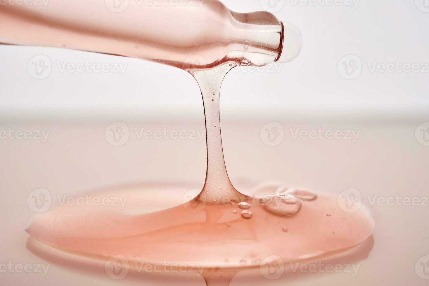 Pipette with a viscous pink cosmetic close-up. photo