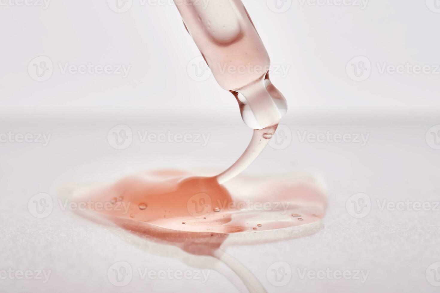 Pipette with a viscous pink cosmetic close-up. photo