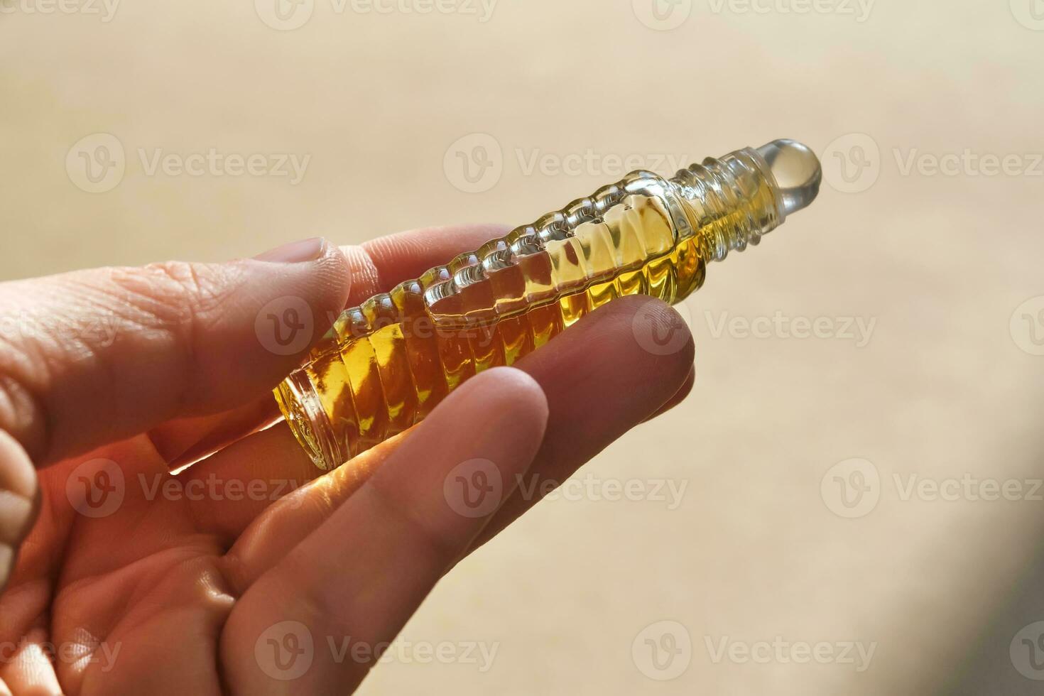 Oil roller perfume on a beige background. photo