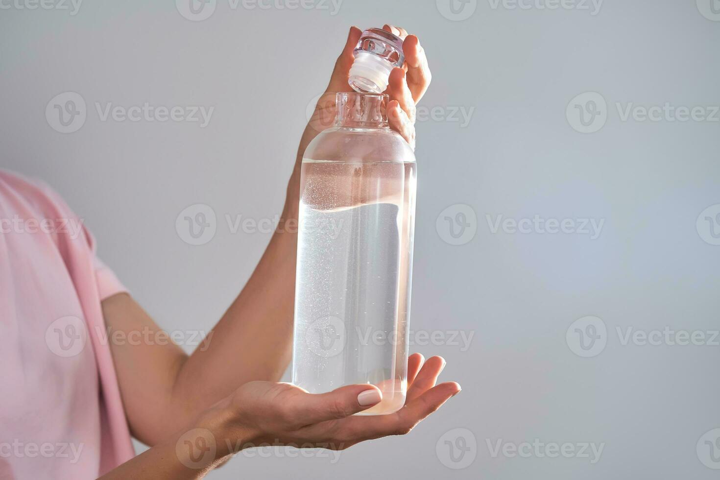 Bottle with drinking water in female hands. photo