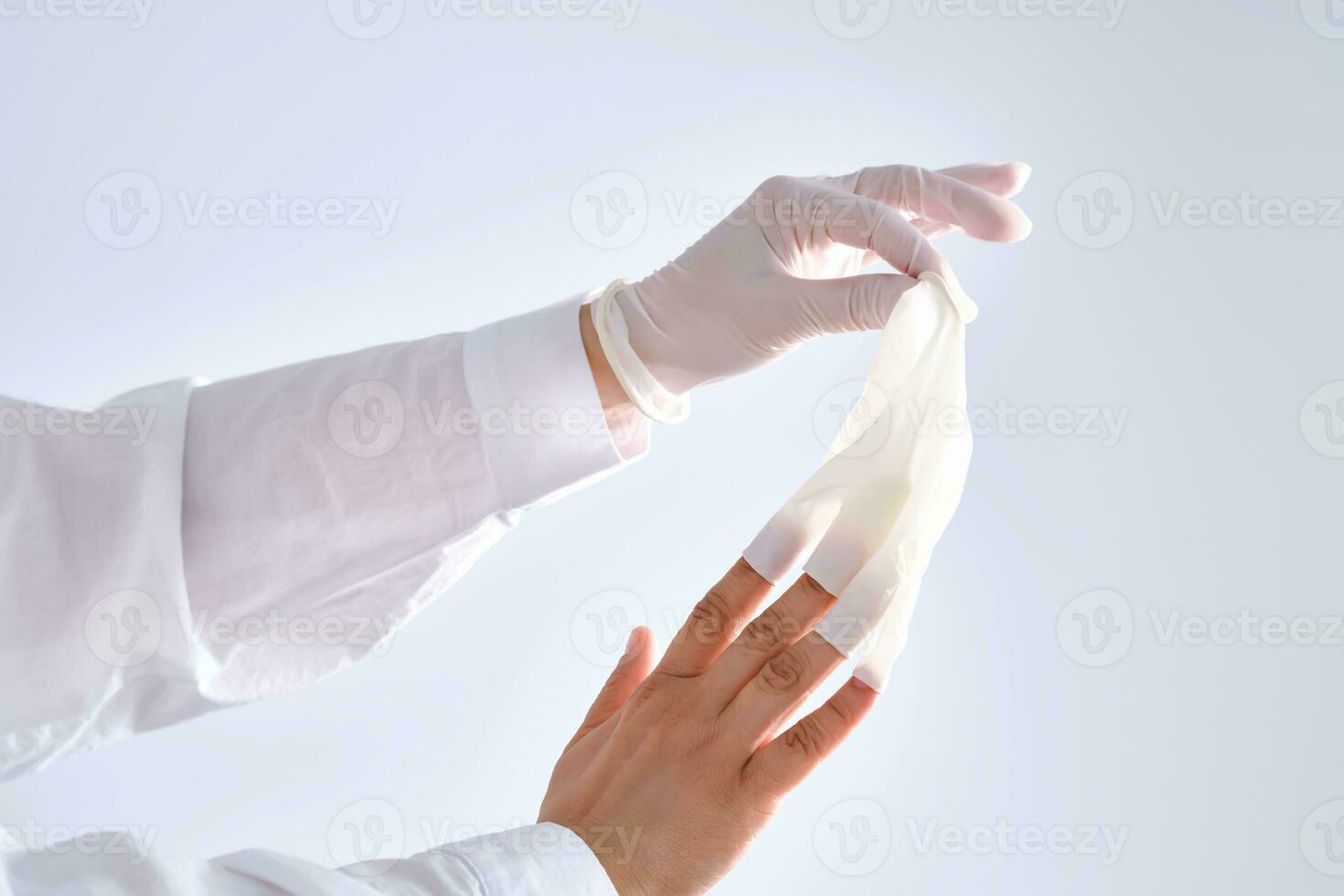 The medical worker removes her white protective gloves. photo