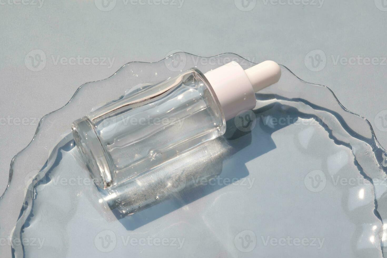 A bottle of serum in water on a blue background. photo
