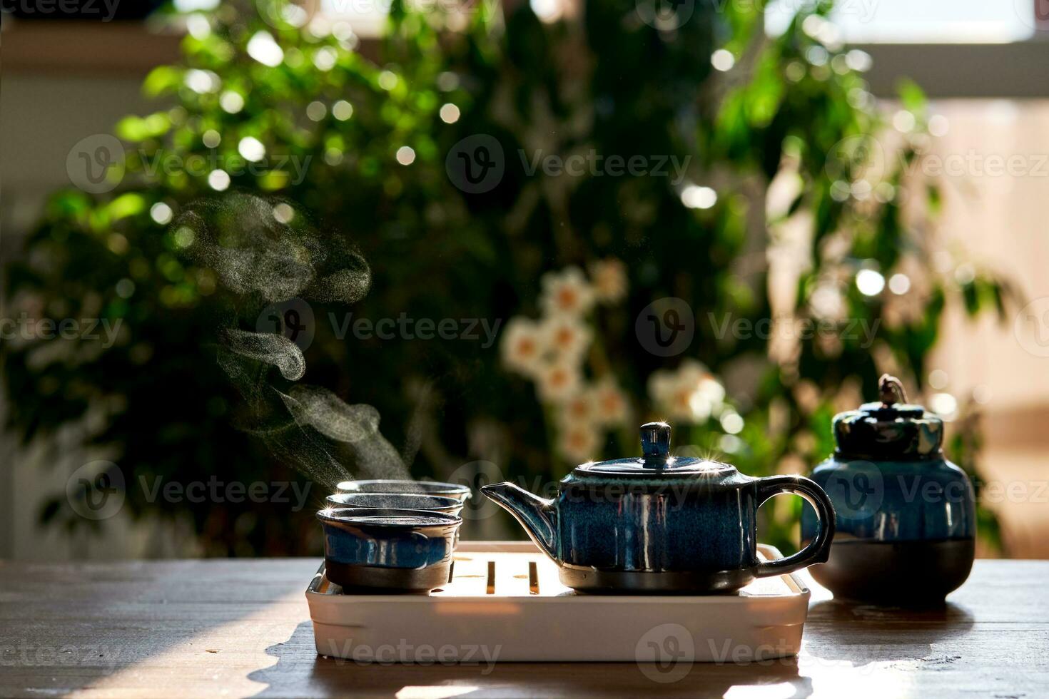 Tea set of deep blue color on a background of greenery. photo