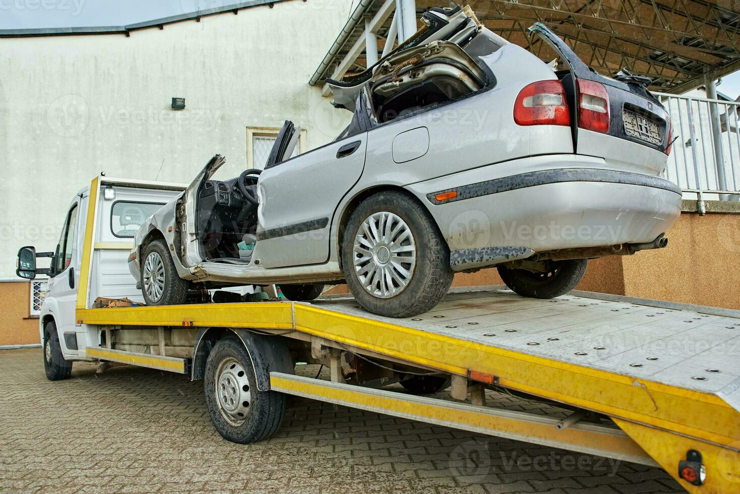 Crashed car loading into tow truck after traffic accident on road photo