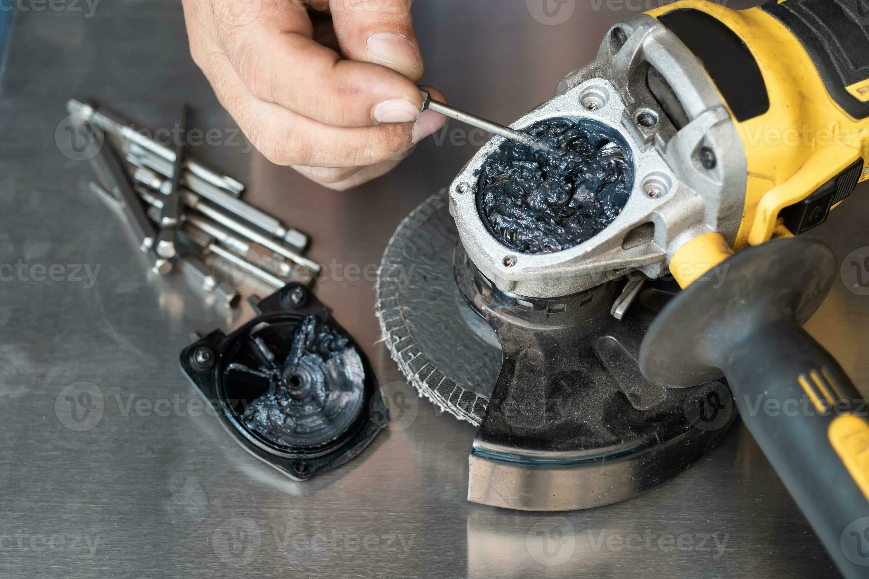 man open up the gear box or Gear housing of old angle grinder and