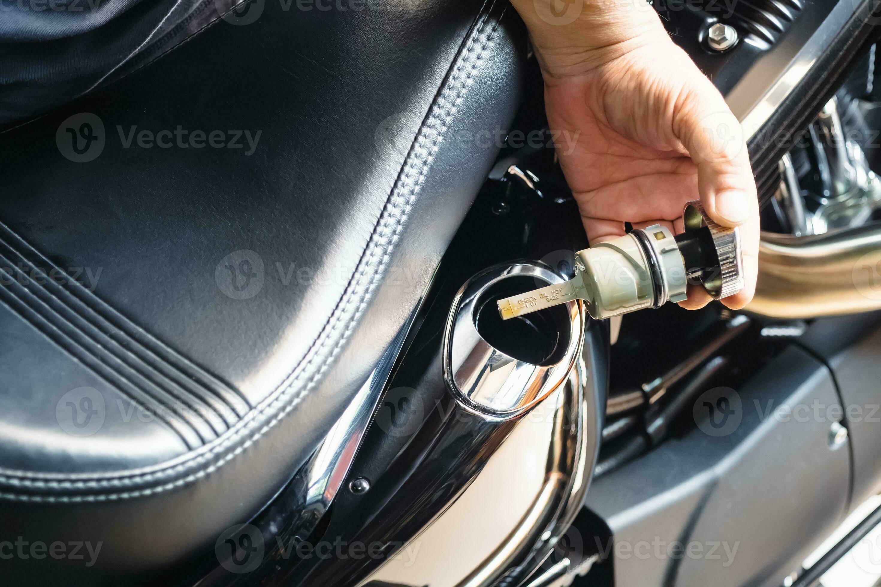 mechanic check engine oil level with oil dipstick on motorcycle or big