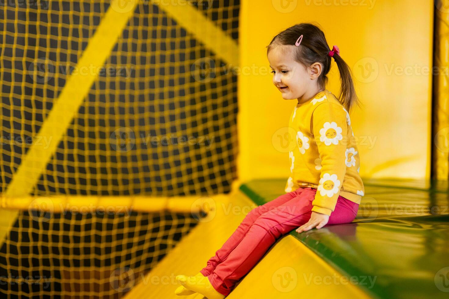 bebé niña niño diapositiva a amarillo patio de recreo parque. niño en activo entretenimientos foto