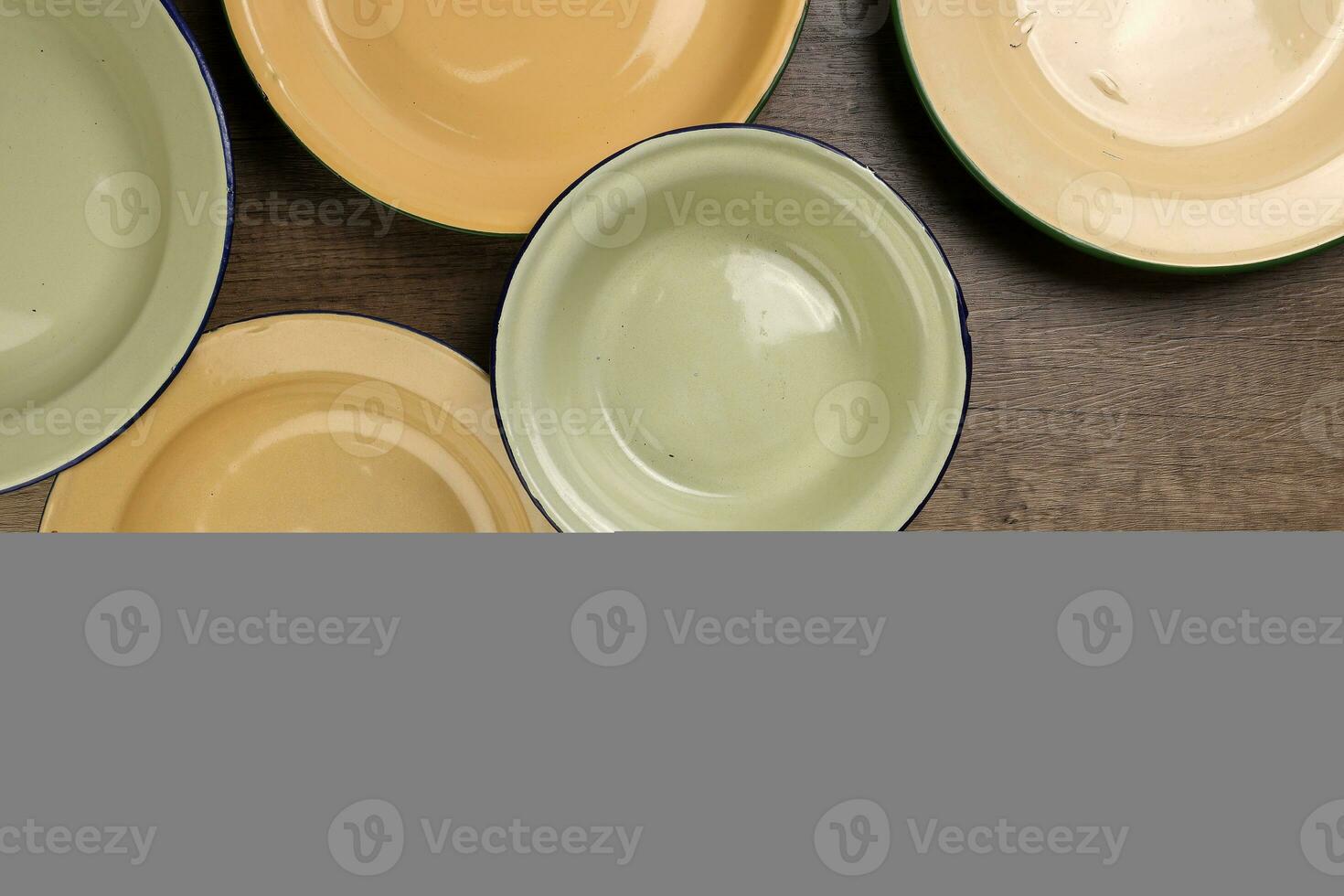 Enamel tin metal food plate pot bowl retro vintage tableware dinnerware on rustic wood background top view photo