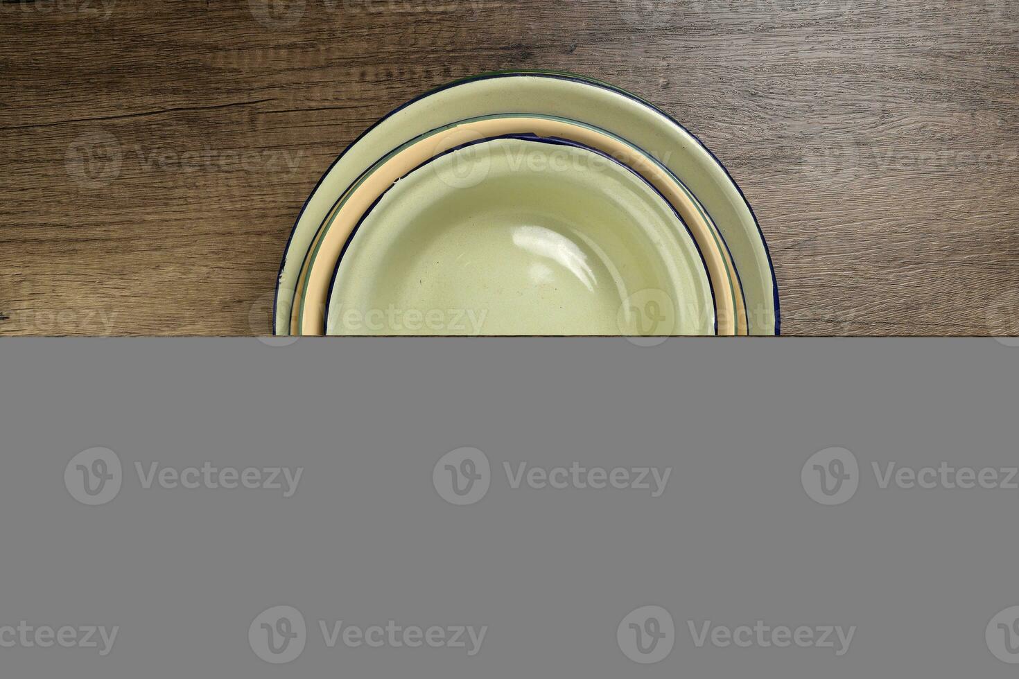 Enamel tin metal food plate pot bowl retro vintage tableware dinnerware on rustic wood background top view photo