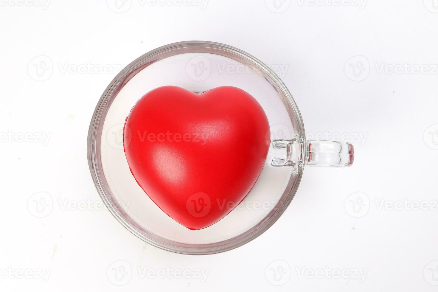 transparent glass coffee tea cup saucer with three dimension 3d red hart symbol inside on white background copy text space top view photo