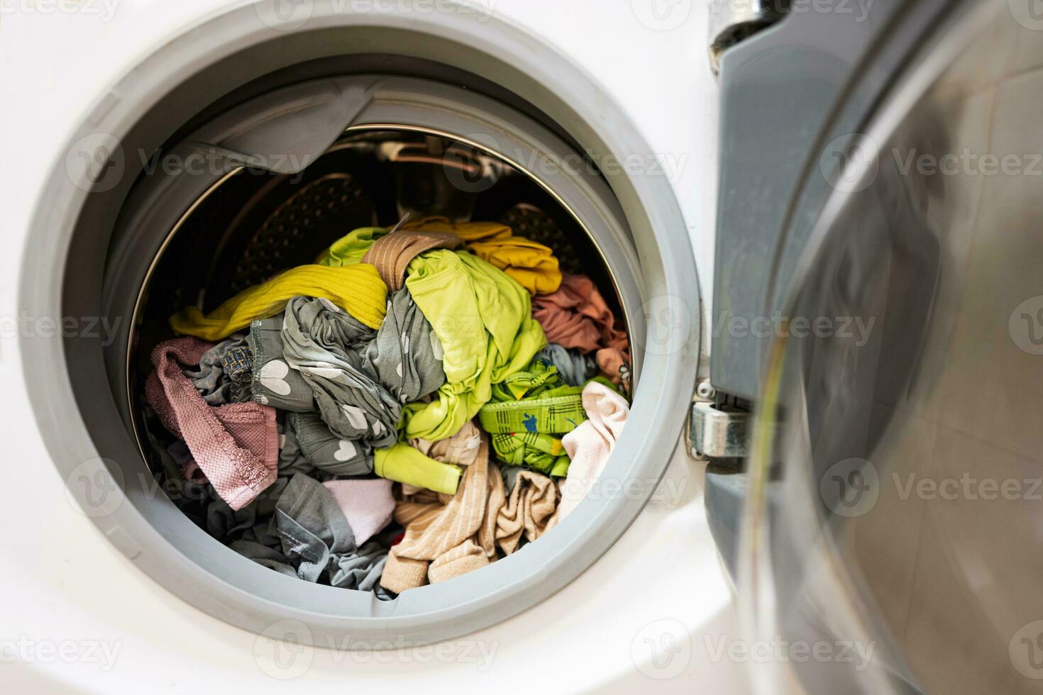 Lavado máquina con un lote de sucio ropa en el lavandería habitación foto