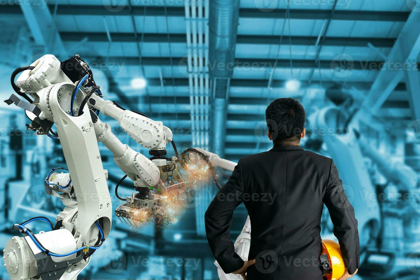 Industrial robot control the engineer in factory photo