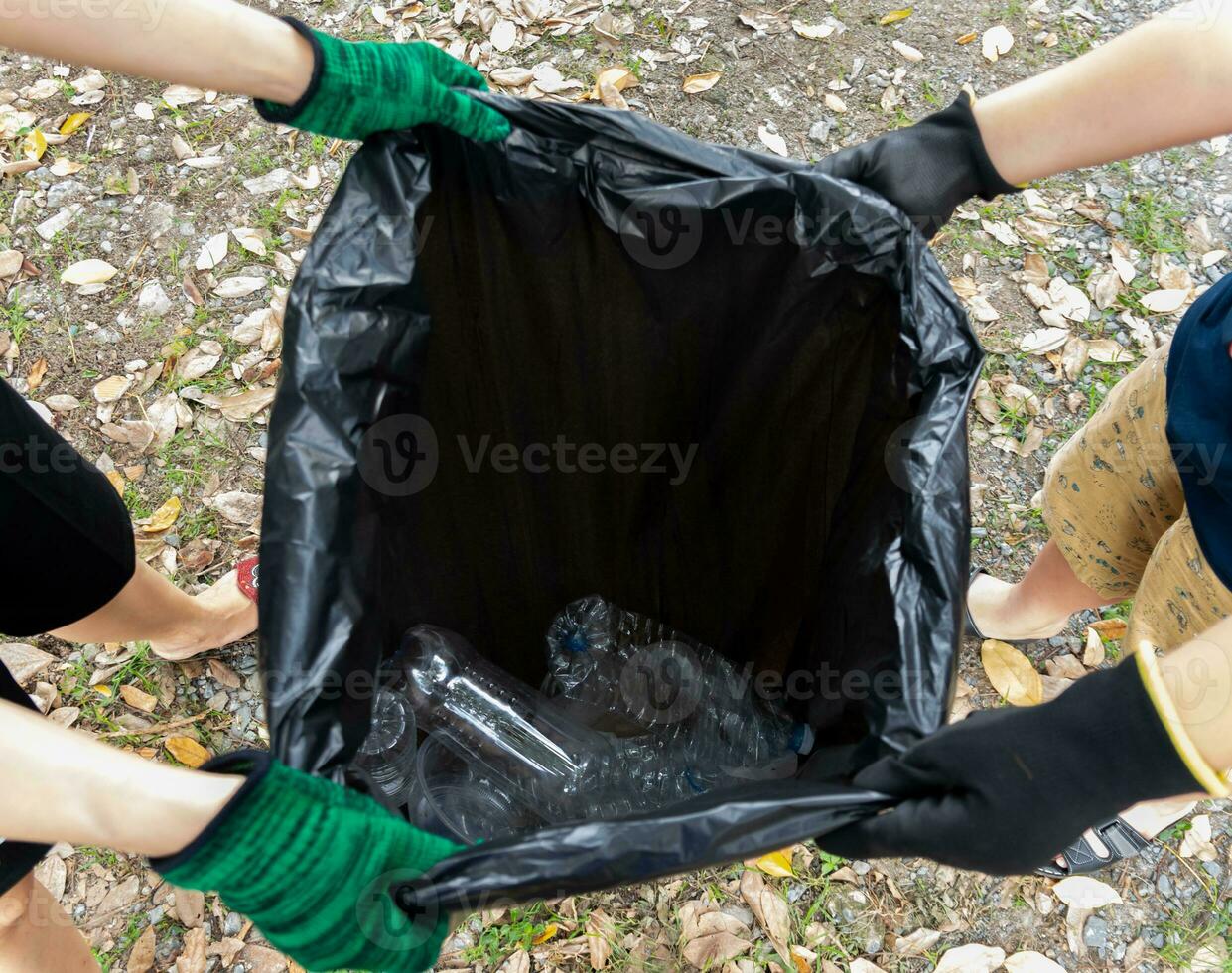 Human hand collect plastic waste in trash bags for the environment photo