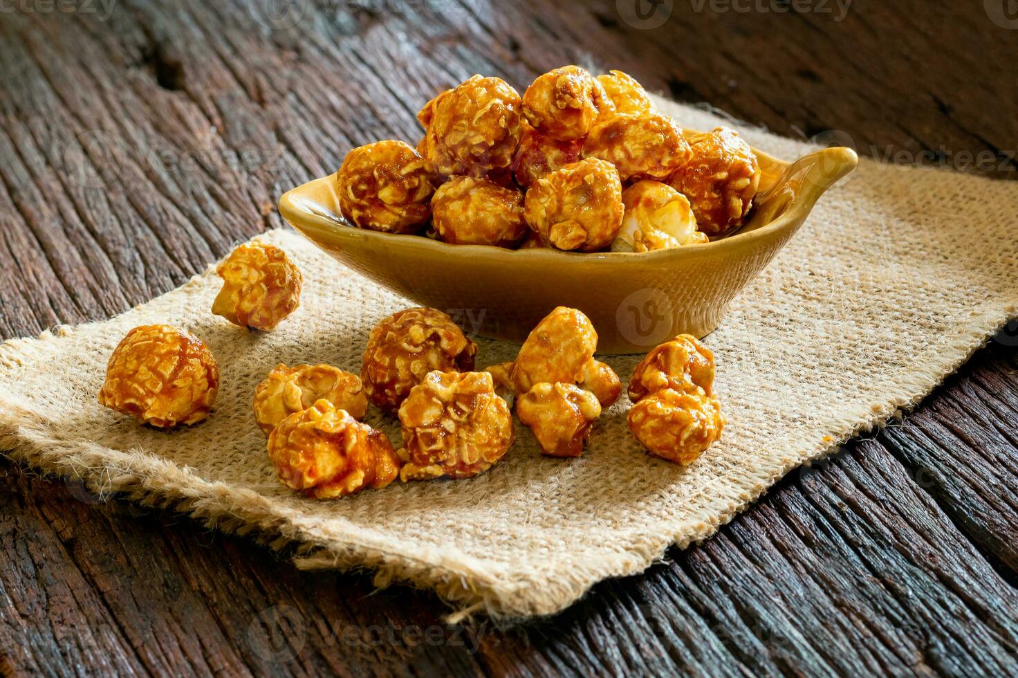 Caramel popcorn in a cup on wooden floor photo