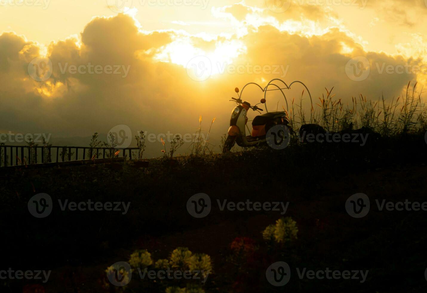 silhouette of motorcycle on mountain view with sunlight photo