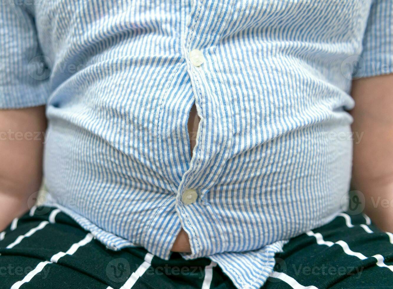 apretado camisa de obeso grasa chico exceso de peso. foto