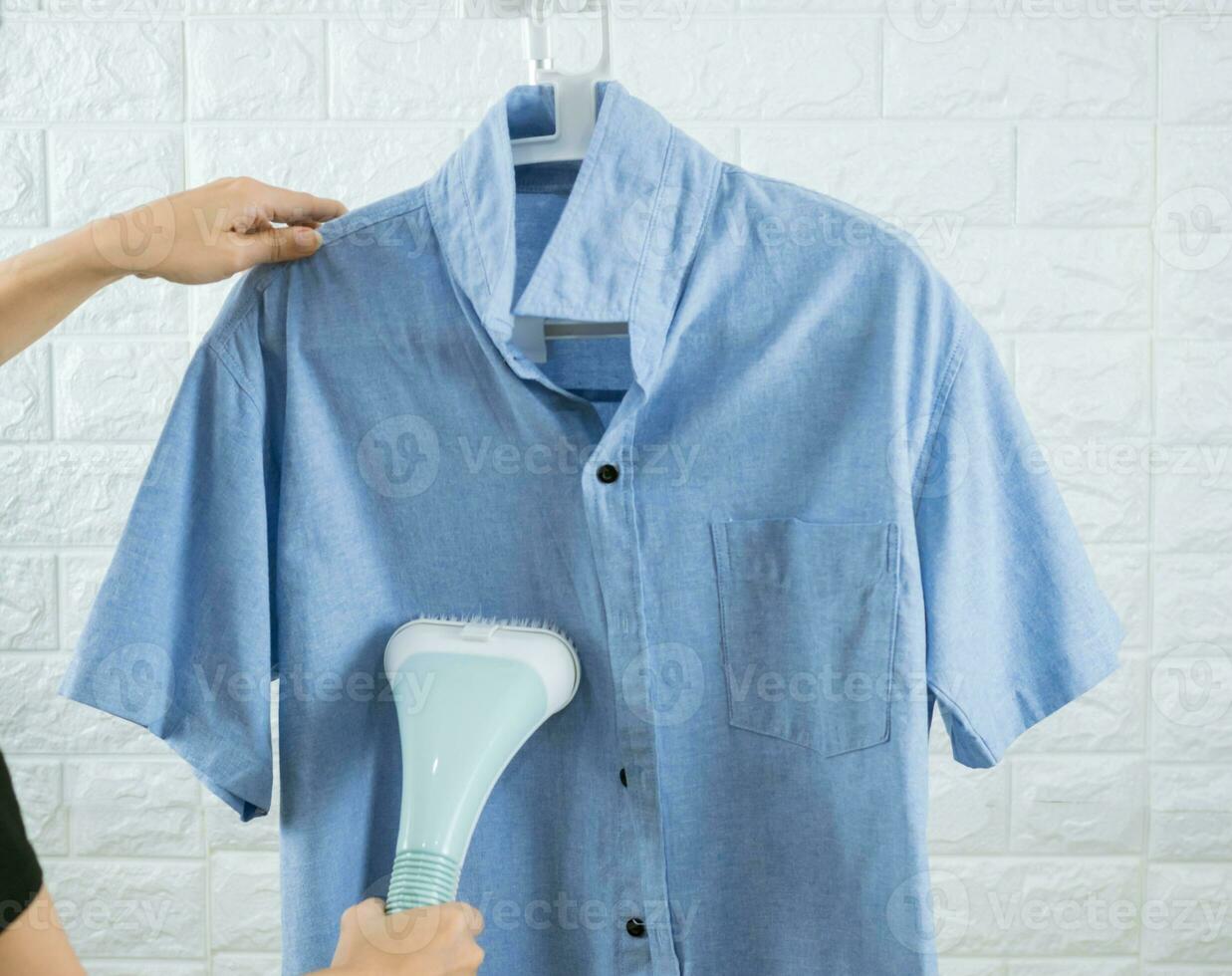 A woman ironing clothes with Steam iron photo