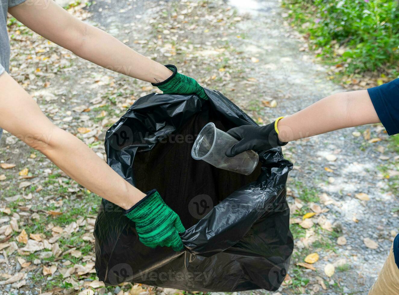 Human hand collect plastic waste in trash bags for the environment photo