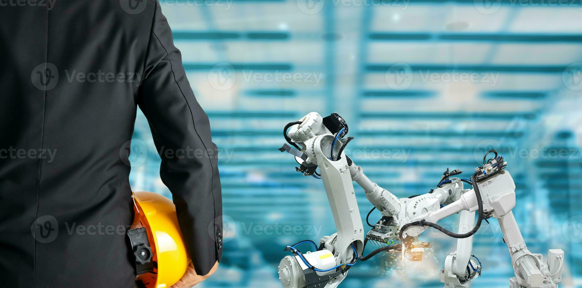 Engineer holding helmet. Industrial robotics concept in factory. photo