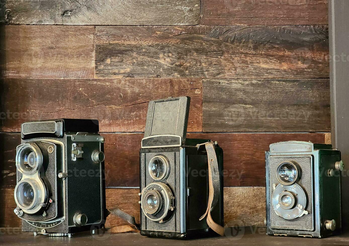 old antique camera the collection is placed on a wooden shelf. photo