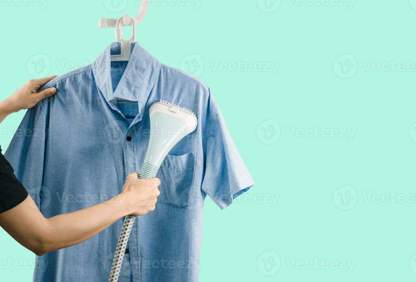 A woman ironing clothes with Steam iron green background photo