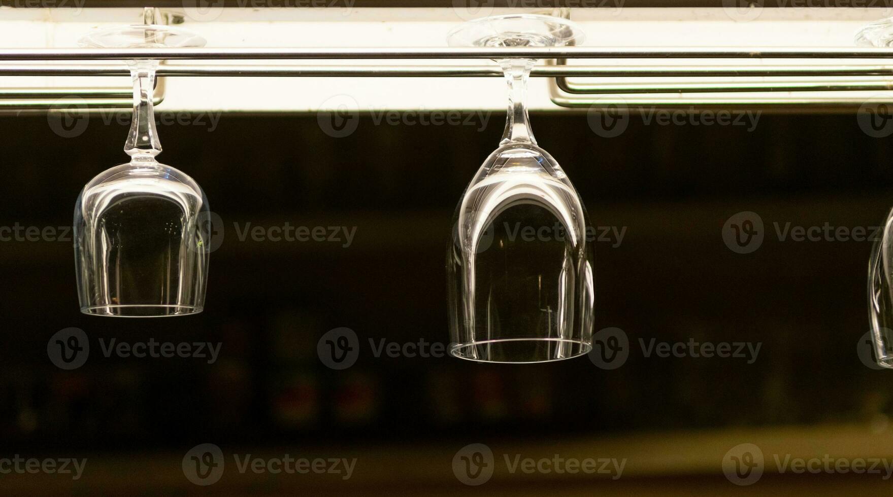 Wine glasses hung on the liquor bar at night. photo