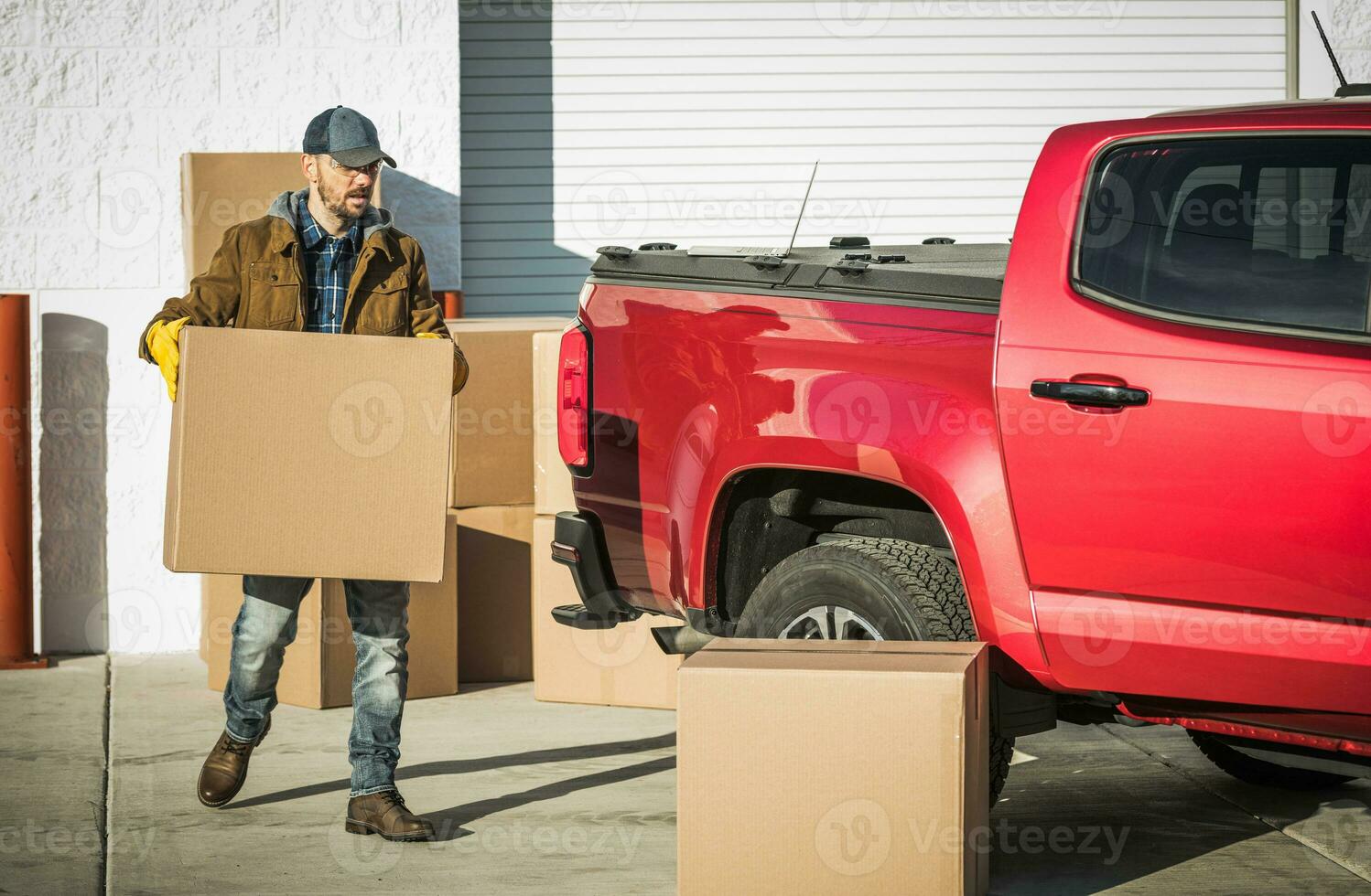 Professional Mover Carrying Cardboard Box to His Car photo