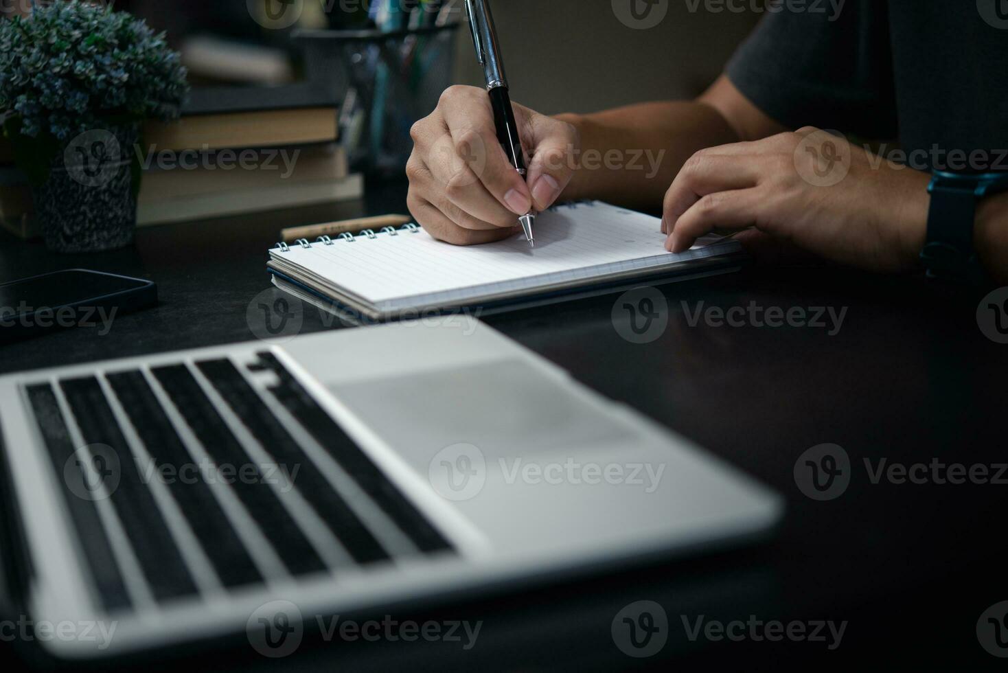 Man hand writing on notebook with computer laptop.Business planning, E learning , journal concept. photo
