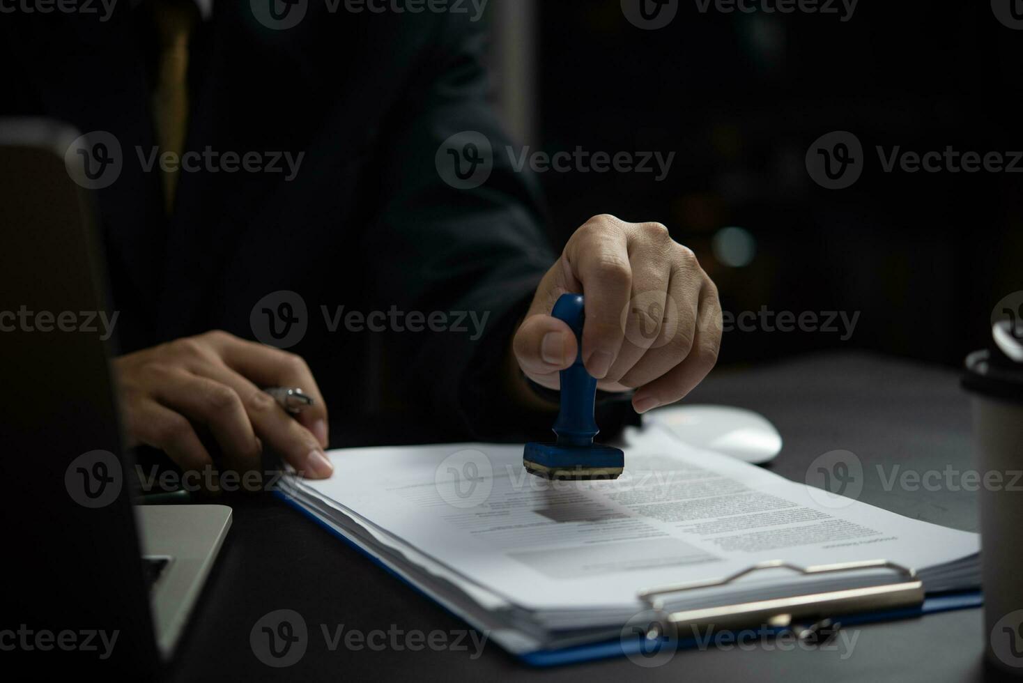 Signing approval record documents stamp confirmation occupation signature. businessman hand stamping finance paper work concept. photo