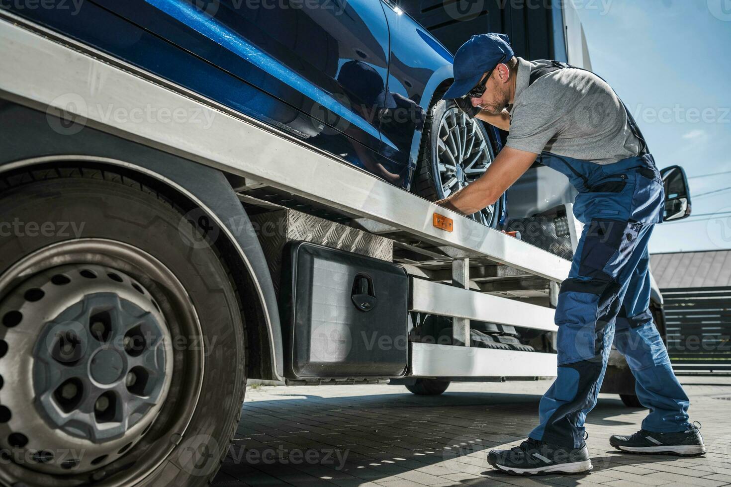 profesional remolcar camión conductor fijación el coche para seguro transporte foto