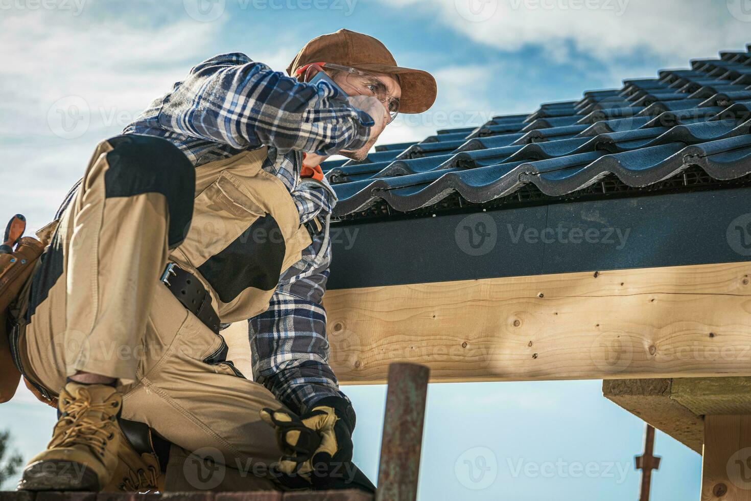Roof Contractor Talking On Cell Phone. photo