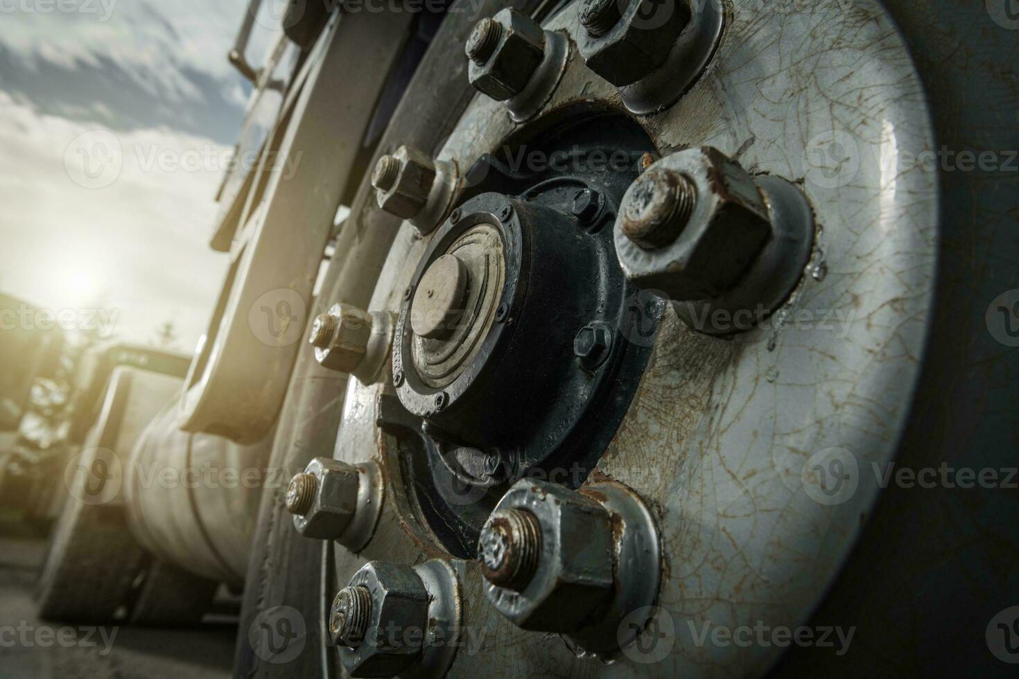 Heavy Duty Aged Truck Wheel and Rusty Nuts Close Up photo