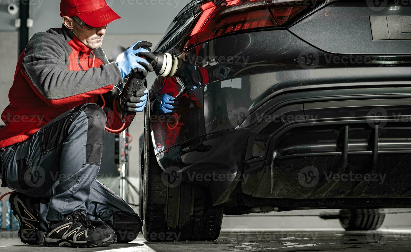 Car Detailing Worker Removing Water From a Car Body Using Soft Cloth photo