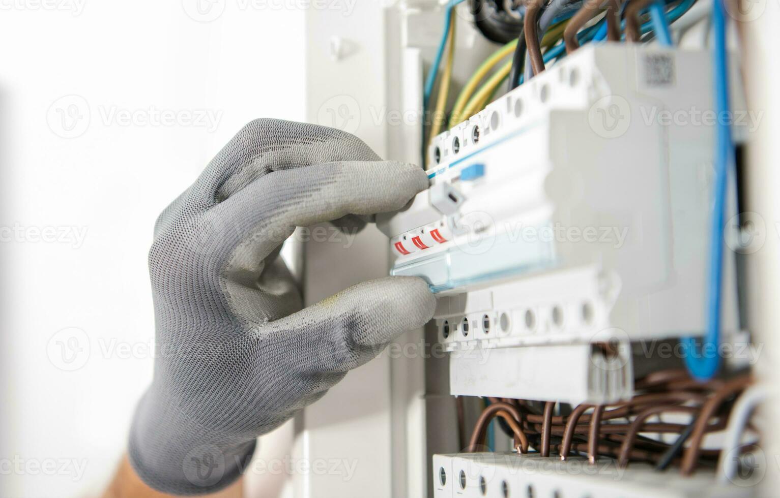 Electrician Testing Fuses In the Electric Box photo
