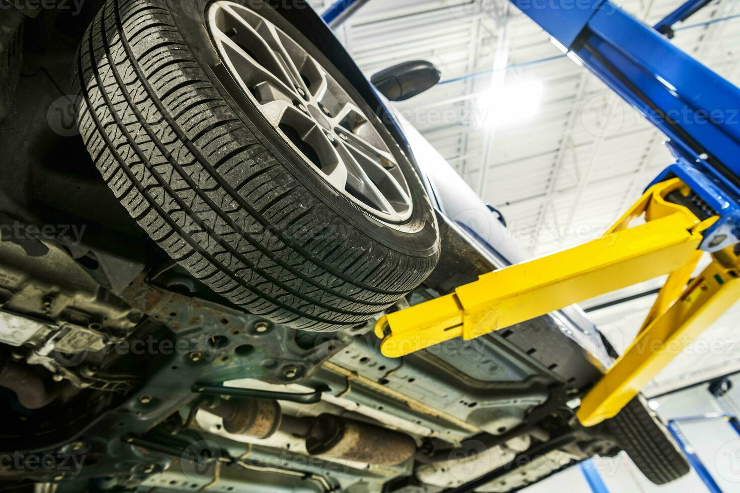 Broken Car on an Automotive Lift Inside Auto Service Center photo
