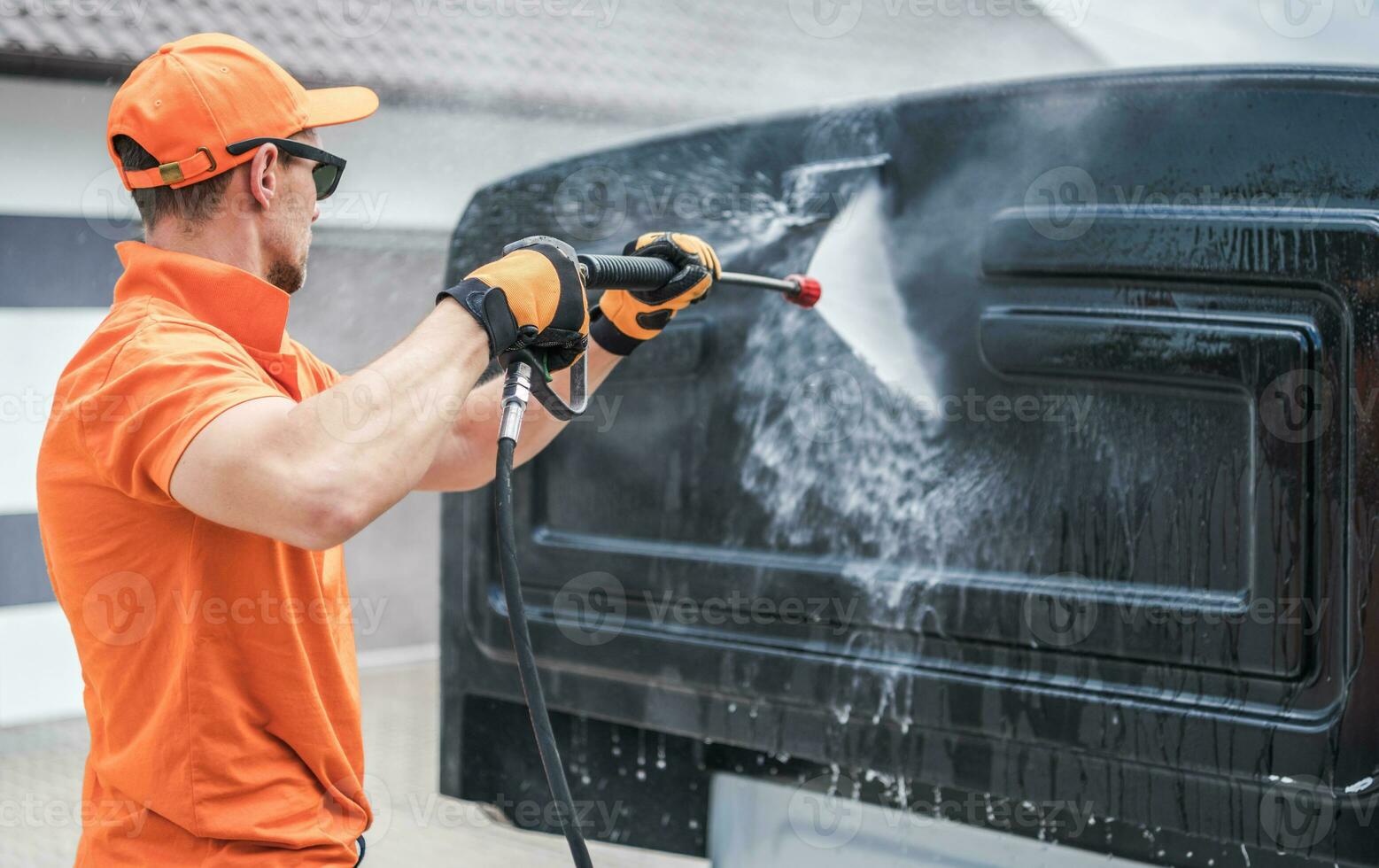 Men Washing Back of His Truck Cabin photo