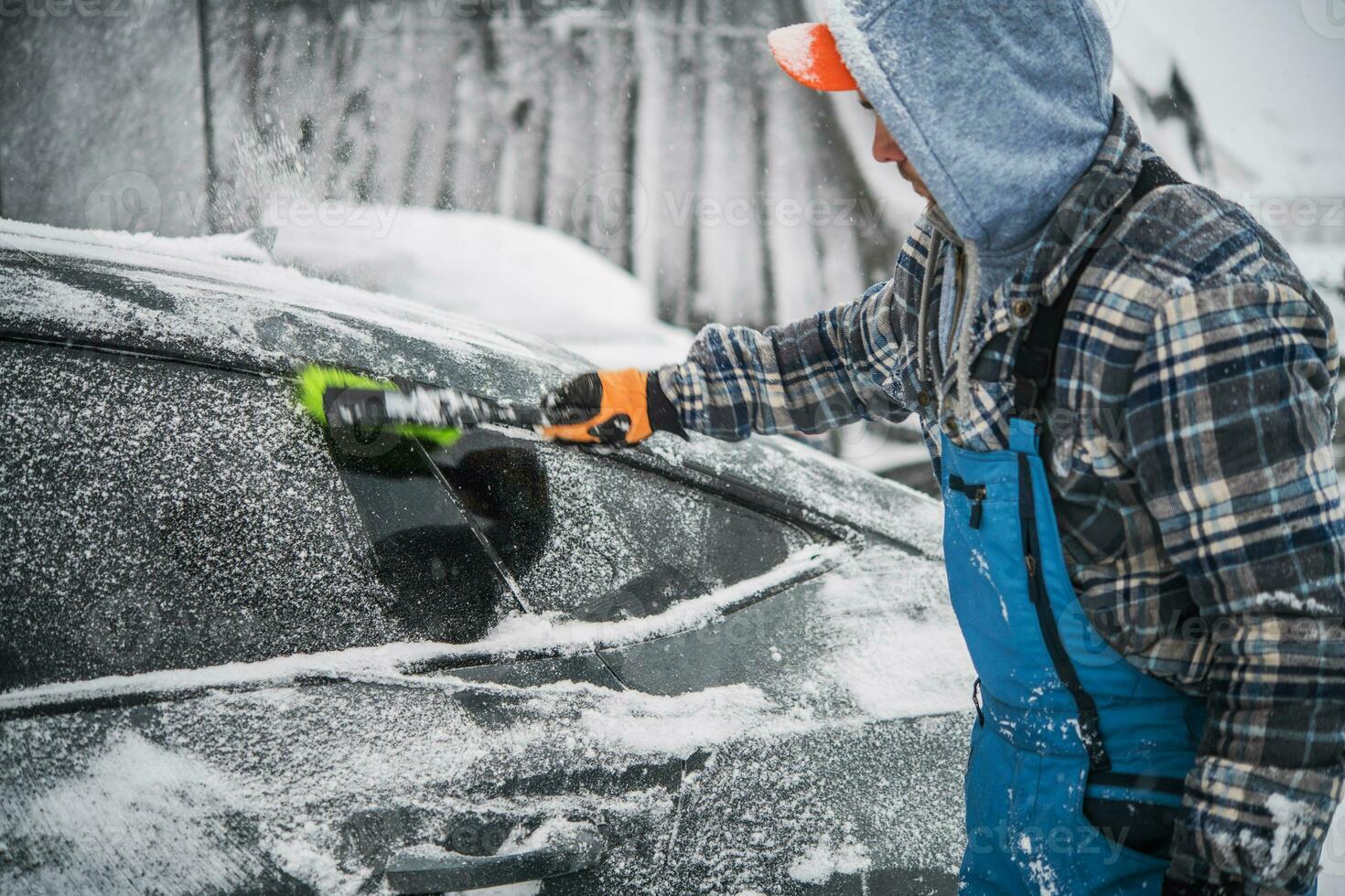 Men Removing Fresh Snow From His Car photo