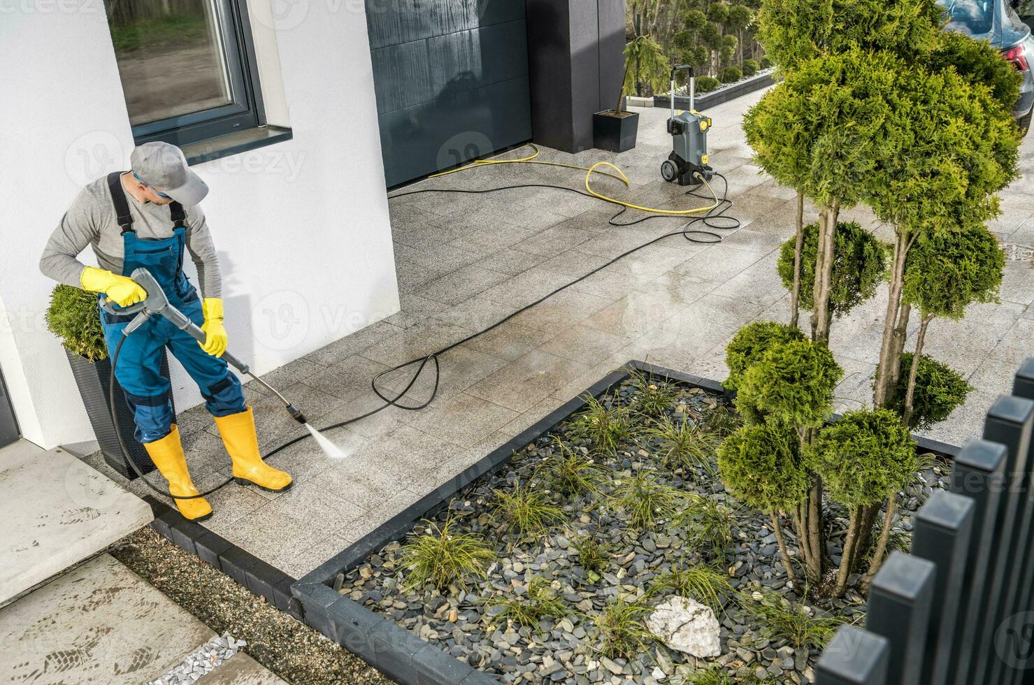 hombres presión Lavado casa rodeando hormigón elementos foto