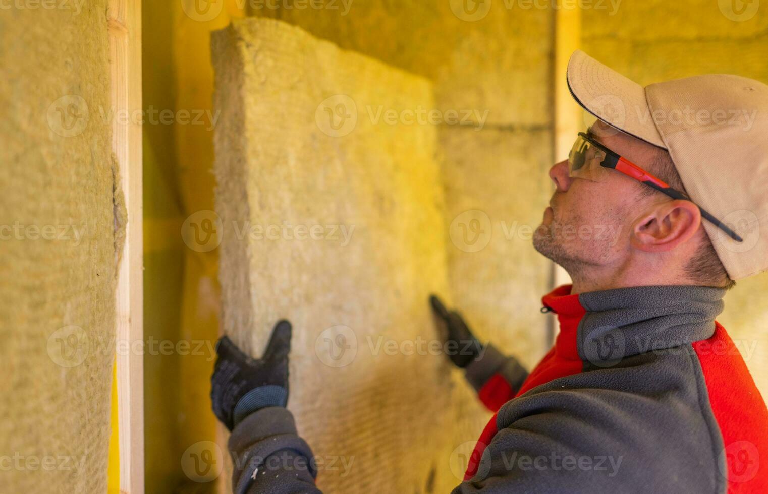 Insulation Contractor Installing High Temperature Mineral Wool Inside House Walls. photo