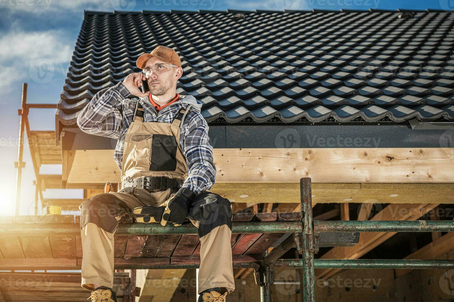 Construction Worker on Phone Call Break at Building Site photo