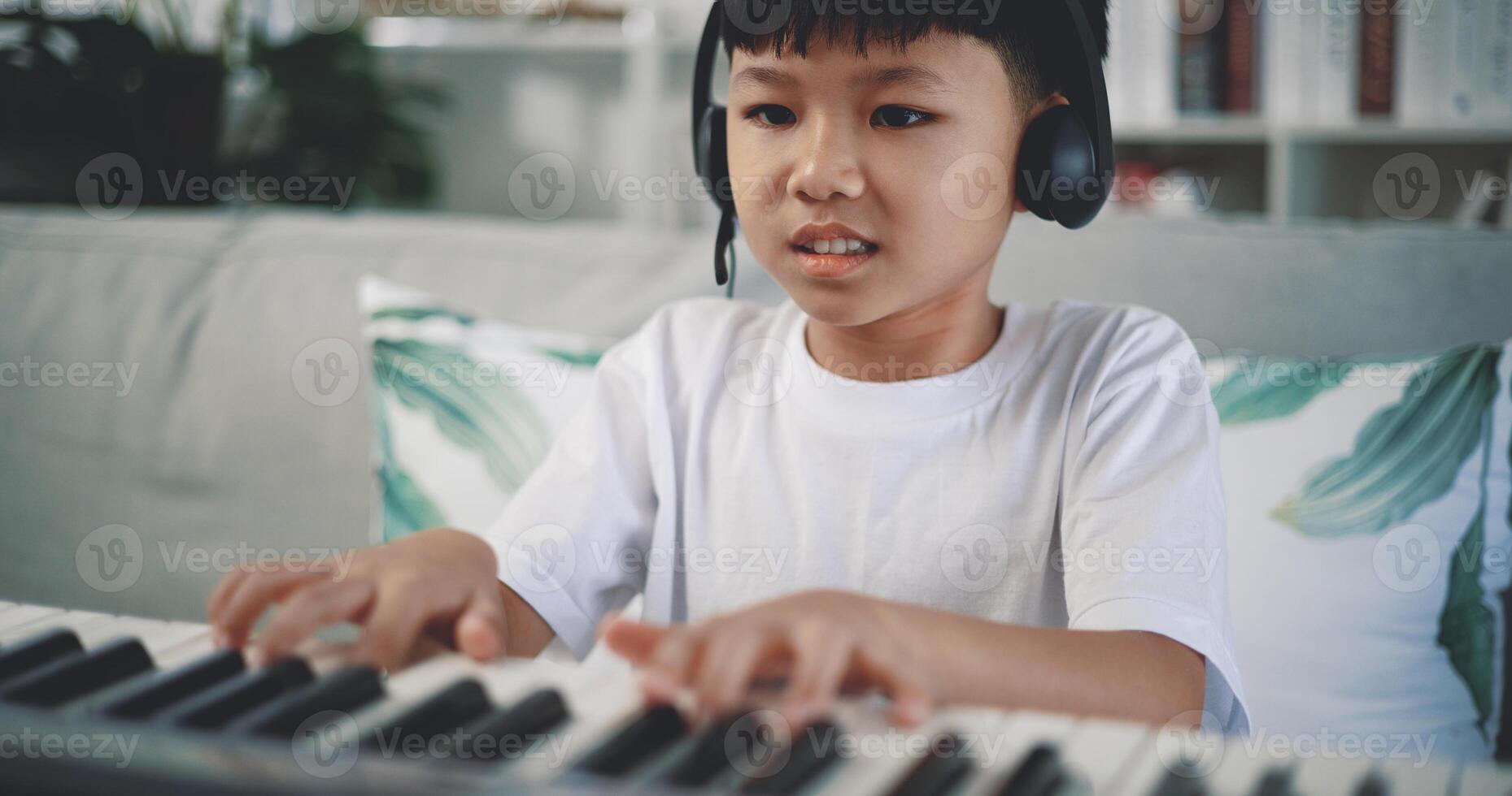 Cute boy enjoy to learning playing piano at home photo