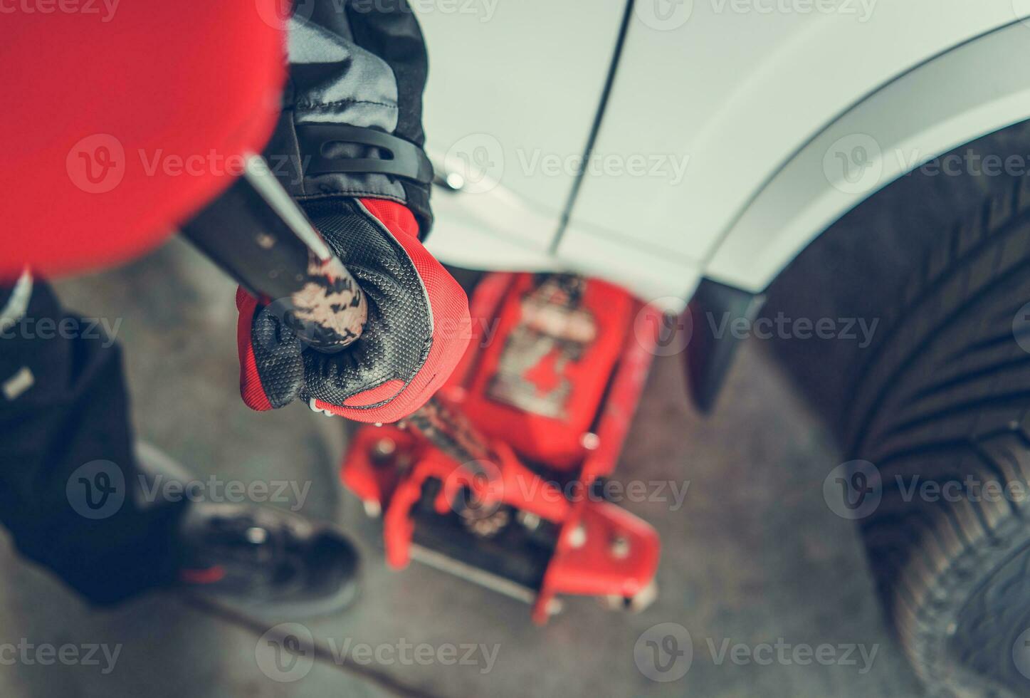 Car Mechanic Lifting Car Using Lift Jack photo